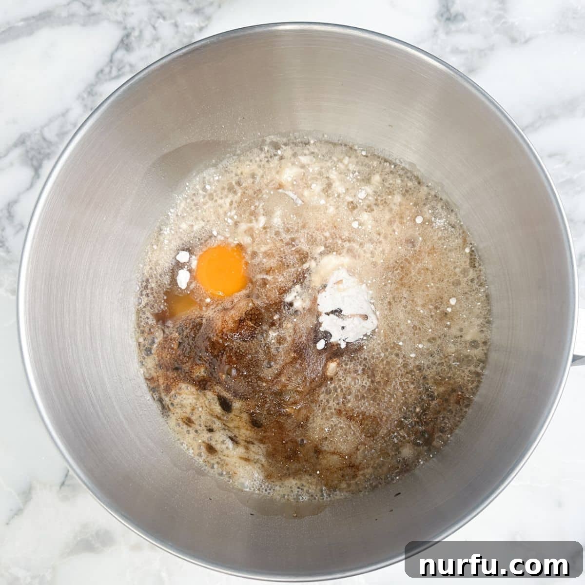 Mixing bowl with eggs, cake mix, and root beer. 