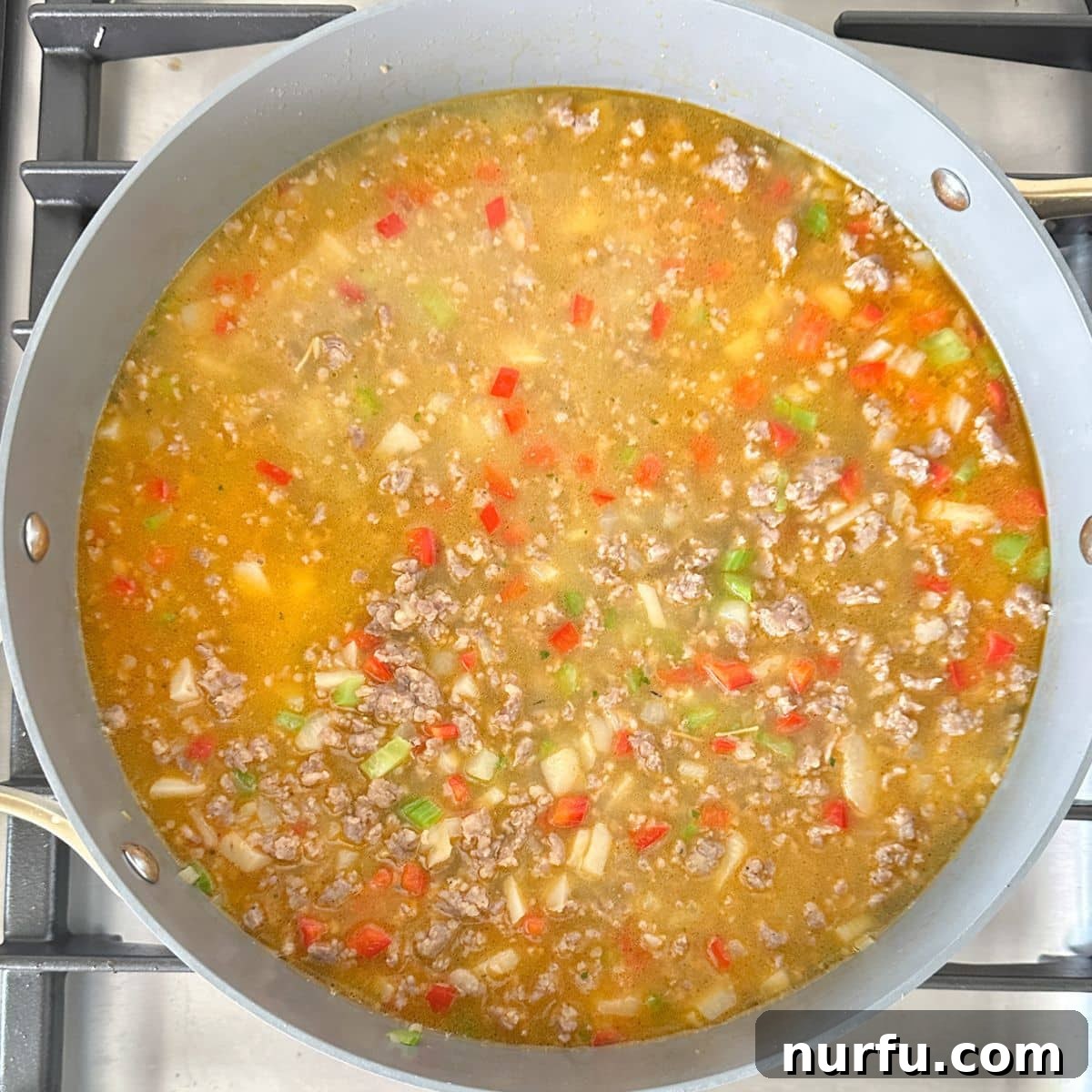 One-Pan Sausage and Rice Casserole 6 Skillet with broth, rice, and vegetables.