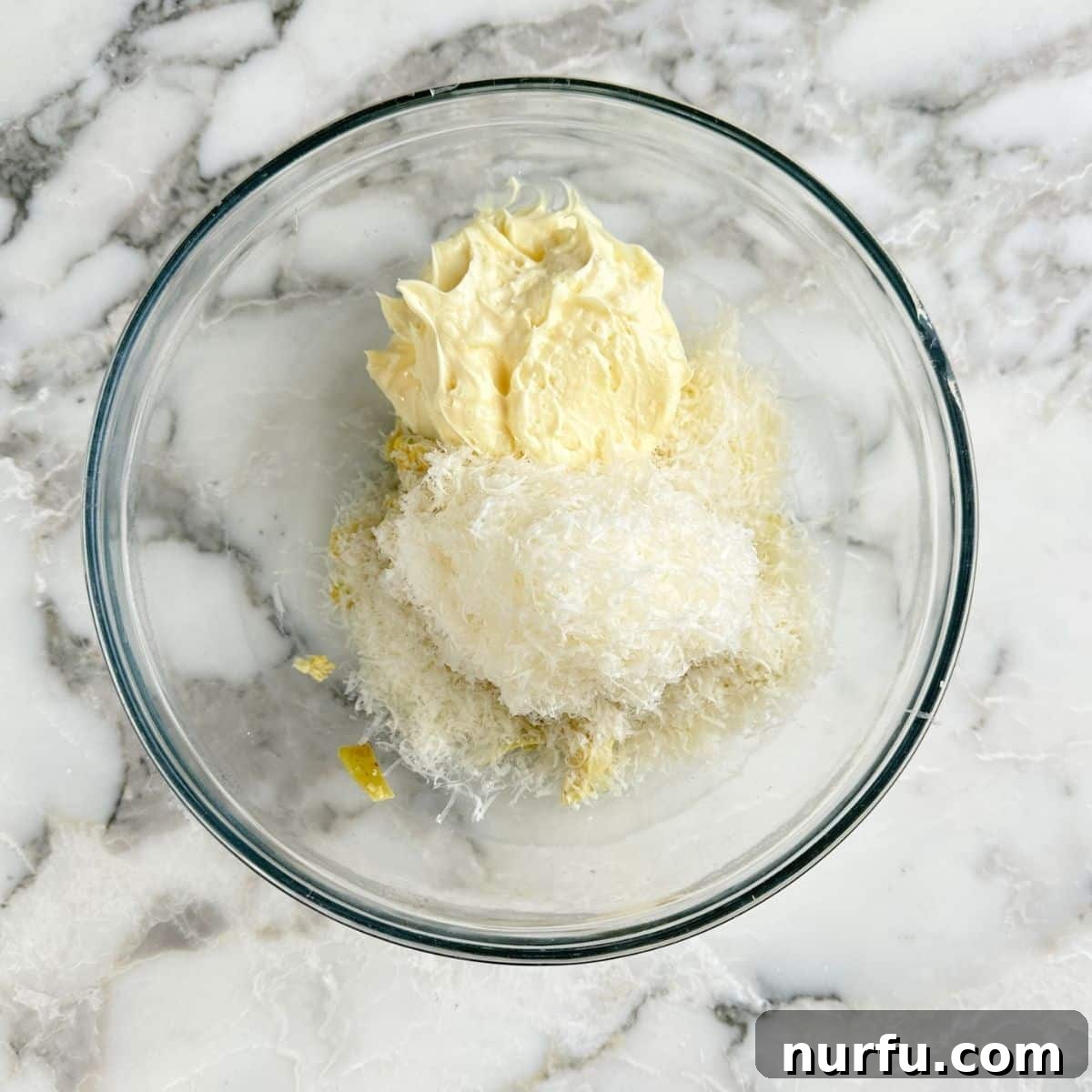 Bowl of artichoke hearts, mayonnaise, and grated parmesan cheese. 