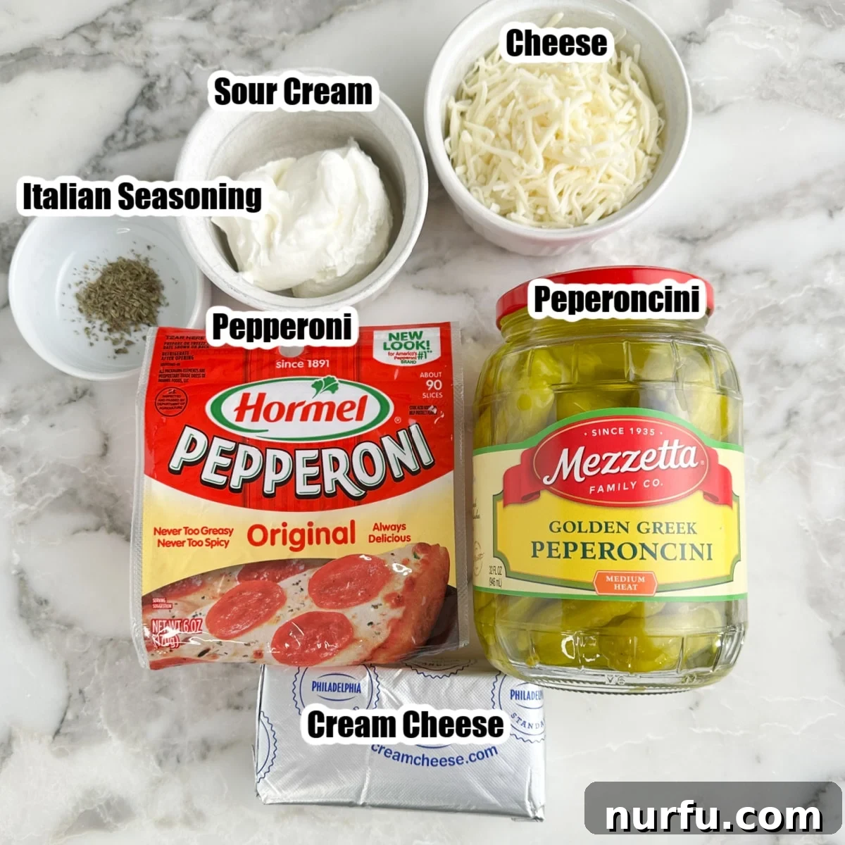 Bag of pepperonis, cream cheese, jar of peperoncini peppers, sour cream, mozzarella, and Italian seasoning.